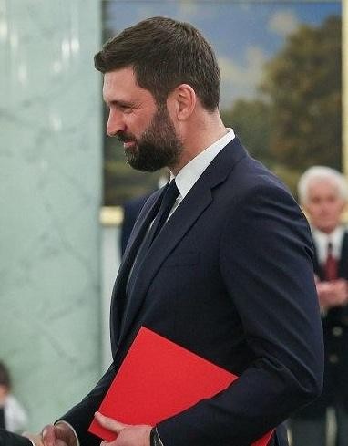 Ilustracja przedstawiająca etapy kariery Nikodema Rachonia, od pracy w sektorze prywatnym, przez dyplomację w Waszyngtonie, po stanowisko w Kancelarii Prezydenta RP, z symbolami reprezentującymi te obszary działalności.