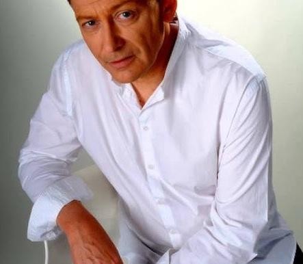 Jacek Borkowski w kuchni, przygotowujący posiłek dla rodziny, symbolizujący jego zaangażowanie w życie domowe.