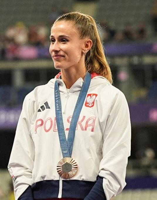 Natalia Bukowiecka, polska lekkoatletka, w zbliżeniu, z wyrazem skupienia i determinacji na twarzy podczas zawodów.