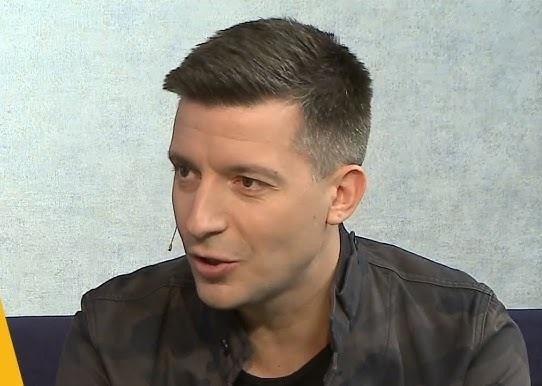 Michał Cessanis w egzotycznym miejscu, z aparatem, w trakcie pracy jako dziennikarz podróżniczy, oddający pasję odkrywania.