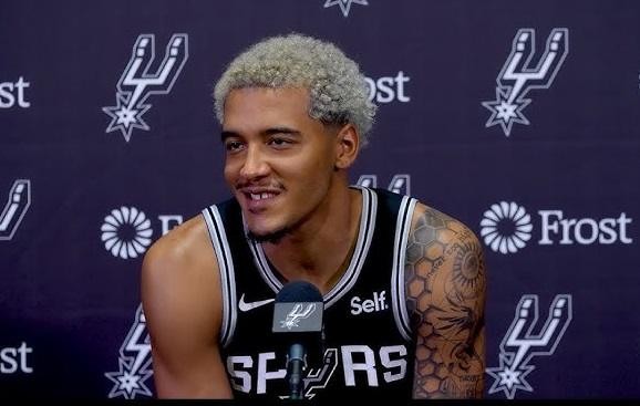 Jeremy Sochan podczas meczu NBA, wykonujący dynamiczną akcję, w koszulce San Antonio Spurs.