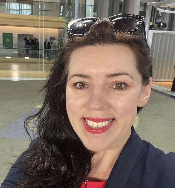 Dominika Ćosić w Brukseli, dynamicznie ujęta w profesjonalnym otoczeniu, symbolizująca jej rolę w polityce międzynarodowej.