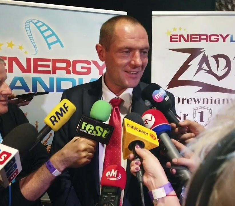 Marek Goczał jako przedsiębiorca w Energylandii i rajdowiec w samochodzie SSV, symbolizujący jego wszechstronną karierę i pasje.