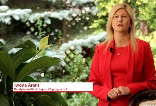 Iwona Arent podczas debaty parlamentarnej lub konferencji prasowej w Sejmie, z dynamicznym gestem i zaangażowanym wyrazem twarzy.